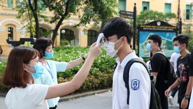 Đo thân nhiệt cho thí sinh. Ảnh: QUANG PHÚC