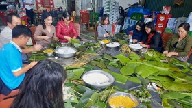 Người dân TP Vinh (Nghệ An) gói bánh chưng chuyển vào ủng hộ đồng bào bị lũ lụt. Ảnh: TRẦN TRUNG HIẾU