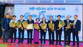 Các lãnh đạo, thành viên Hiệp hội Du lịch TPHCM nhận hoa chúc mừng ngày 11-1. Ảnh: THI HỒNG
