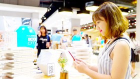 A buyer is paying her bill conveniently via e-wallet service at Phuong Nam Bookstore. (Photo: SGGP)
