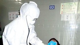 A medical worker examines a patient in a drill (Photo: SGGP)