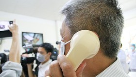 Deputy Minister of Health Nguyen Truong Son (L) communicates with Vietnamese American COVID-19 patient who is allowed to be discharged from the hospital (Photo: SGGP)