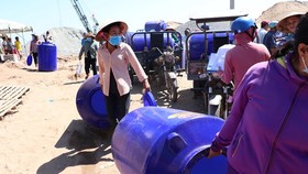 Poor residents in Ben Tre are happy to receive water containers (Photo: SGGP)