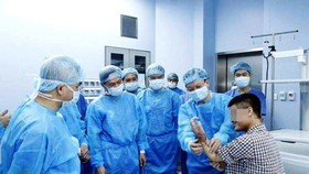 Surgeons are examining the man's hand after operation (Photo: SGGP)