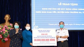 Deputy Secretary of the municipal Party Committee Vo Thi Dung gives support money to Deputy Commander of the Vietnam People's Navy Rear Admiral Luong Viet Hung (Photo: SGGP)