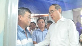 Secretary of the Ho Chi Minh City People’s Committee Nguyen Thien Nhan (1st, R) expresses his condolence to the bereaved father (Photo: SGGP)