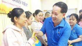 A representative of HCMC Federation of Labor is delivering financial aid to unemployed people due to the Covid-19 pandemic. (Photo: SGGP)