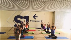 Staff of the VTC Television practise yoga during a break. (Photo: VNA)