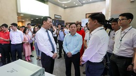 Minister of Information and Communications Nguyen Manh Hung paid a tour to ‘Make in Vietnam’ technological products in an exhibition in the framework of the conference. (Photo: SGGP)