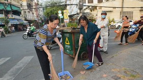 People clean streets in response to city authorities' campaign (Photo: SGGP)
