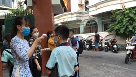 Teachers of Kien Thiet High School in District 3 take students' temperature (Photo: Dan Thuy)