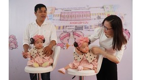 The twins can sit with support from their parents (Photo: SGGP)