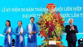 Mr. Tran Quoc Vuong presents flowers to congratulation on the Vietnam Women's Union (Photo: SGGP)