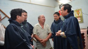 Secretary of Ho Chi Minh City Party Committee Nguyen Van Nen (R) and Chairman of HCMC People's Committee Nguyen Thanh Phong (L) visit people in flood hit areas in Thu Duc District (Photo: SGGP)