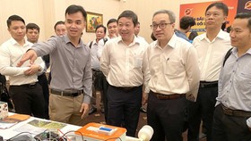 Deputy Minister of Information and Communications Phan Tam, Vice Chairman of HCMC People’s Committee Duong Anh Duc, and other delegates are visiting the ICT product exhibition