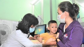 A physician is examining a child in Tan Binh District's medical center (Photo: SGGP)