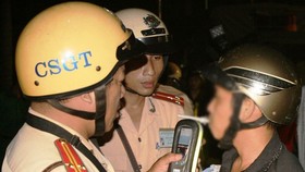Police officers check a driver's blood alcohol level