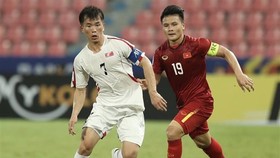 Team captains of Vietnam Nguyen Quang Hai (in red) and the DPRK Ri Chung-gyu vie for the ball (Photo: VNA)