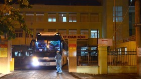 A worker sprays disinfectant at the gate of Da Nang Hospital, which is now a hot spot of COVID-19 in Vietnam.