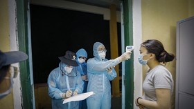 Health workers record health information of a woman at a quarantine site (Photo: VNA)