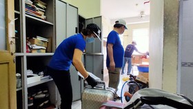 Các thầy cô trường ĐHQG TP.HCM thu dọn toà nhà Công đoàn nhường chổ cho những người cách ly mới Ảnh: HOÀNG HÙNG