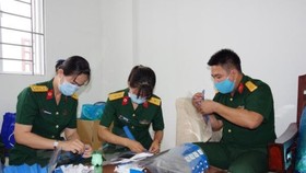 Các bác sĩ Bệnh viện Dã chiến 2.3 tận dụng thời gian sau huấn luyện để làm ra sản phẩm nón kính phòng hộ. ẢNH: TRẦN CHÍNH