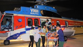 Lực lượng nhân viên y tế và nhân viên sân bay vận chuyển bệnh nhân từ trực thăng về bệnh viện