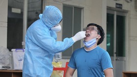 Nhân viên Trung tâm y tế quận 6 ̉lấy mẫu xét nghiệm cho người dân trên địa bàn. Ảnh: HOÀNG HÙNG