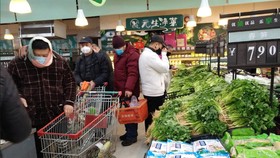 Người dân Trung Quốc đeo khẩu trang khi mua sắm tại một siêu thị, ngày 26-1-2020. Ảnh: CNS/REUTERS 
