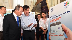 Bí thư Thành ủy TPHCM Nguyễn Thiện Nhân xem ứng dụng Sở Xây dựng trực tuyến SXD247, ra mắt tháng 12-2019 nhằm phục vụ tốt hơn nhu cầu của người dân về lĩnh vực xây dựng. Ảnh: VIỆT DŨNG