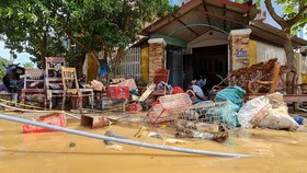 Người dân ở thị trấn Kiến Giang, huyện Lệ Thủy, Quảng Bình dọn dẹp nhà cửa sau khi lũ rút. Ảnh: MINH PHONG