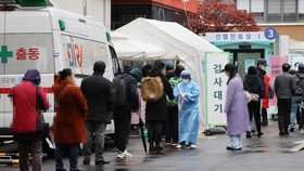 Người dân xếp hàng chờ xét nghiệm virus tại một phòng xét nghiệm tạm thời ở Seoul, ngày 22-11-2020. Ảnh: YONHAP