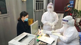 Nhân viên y tế làm thủ tục thăm khám cho người bệnh tại khu vực phòng khám "dã chiến" của Bệnh viện Phụ sản Trung ương. Ảnh: ncov.moh.gov.vn