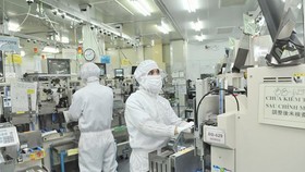 Workers at a company making electronic components for export in Vietnam (Photo: SGGP)