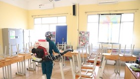 A worker sprays disinfectant at a classroom of the Viet Duc High School in Hanoi's Hoan Kiem district on February 2 (Photo: VNA)