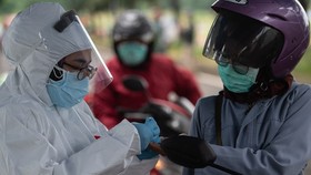 A health worker takes a motorcyclist's blood sample for COVID-19 testing in Tangerang city, Indonesia, on May 4 (Photo: AFP/VNA)