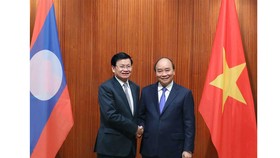 Prime Minister Nguyen Xuan Phuc meets with his Lao counterpart Thongloun Sisoulith during the Lao PM's visit to Vietnam on July 5. (Photo: VNA)