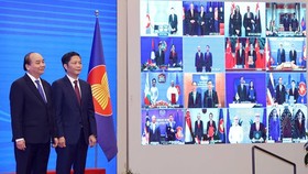 Vietnamese Prime Minister Nguyen Xuan Phuc (L) and Minister of Industry and Trade Tran Tuan Anh, together with leaders of other RCEP member countries, witness the pact signing via videoconference on November 15 (Photo: VNA)