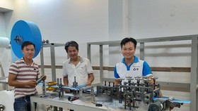 PGS.TS Nguyễn Hữu Lộc (giữa) và TS Nguyễn Thanh Hải (phải) bên máy tạo thân khẩu trang y tế.