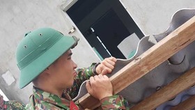 Bộ đội giúp dân lợp lại mái nhà bị gió bão đánh tốc ở huyện Phong Điền, tỉnh Thừa Thiên - Huế 