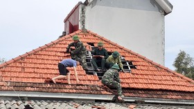 Lực lượng chức năng giúp người dân xã Thịnh Lộc, huyện Lộc Hà lợp lại mái nhà sau thiệt hại do lốc xoáy gây ra
