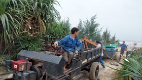 Sáng 25-10, ngư dân ở thị trấn Thiên Cẩm (huyện Cẩm Xuyên, Hà Tĩnh) kéo tàu lên bờ tránh bão