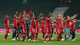Bayern hướng về khán đài trống chia sẻ vinh quang với người hâm mộ. Ảnh: Getty Images