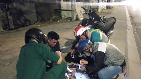 Các thành viên Đội cứu trợ giao thông quận 12 giúp đỡ người bị té xe dọc đường