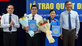 Phó Bí thư Thường trực Thành ủy TPHCM Trần Lưu Quang (bìa trái) và Trưởng ban Công tác phía Nam Cơ quan Ủy ban Trung ương MTTQ Việt Nam Võ Văn Thiện (bìa phải) trao quyết định nhân sự mới