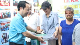 Bí thư Quận ủy quận 5 Nguyễn Văn Hiếu tặng thùng rác cho các hộ gia đình tại lễ ra mắt hẻm xanh - sạch - văn minh ở phường 1, quận 5. Ảnh: MAI HOA