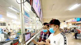 Hành khách chọn tuyến, giờ xe chạy tại Bến xe Miền Đông qua màn hình điện tử. Ảnh: CAO THĂNG