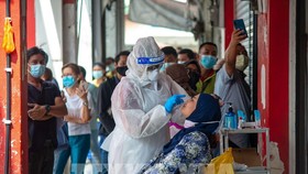 Nhân viên y tế lấy mẫu xét nghiệm COVID-19 cho người dân tại Selangor, Malaysia ngày 23-10-2020. Ảnh: THX/TTXVN