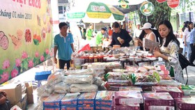 Khách hàng chọn mua các loại bánh mứt và đặc sản của tỉnh Đồng Tháp tại phiên chợ “Tết xanh - quà Việt” tổ chức tại TPHCM từ ngày 17 đến 22-1