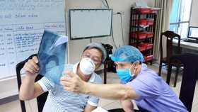 Thứ trưởng Bộ Y tế Nguyễn Trường Sơn (trái) trực tiếp theo dõi tình hình sức khỏe bệnh nhân Covid-19 tại Bệnh viện Phổi Đà Nẵng. Ảnh: NGUYỄN CƯỜNG